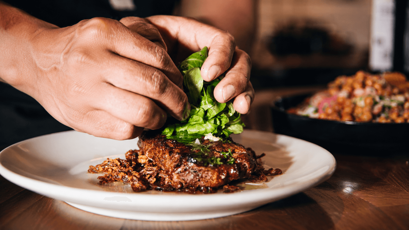 A close-up of food being finished by hand
